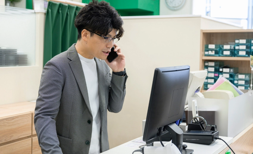 T.T.さん　パソコンで管理画面を見ながら電話をしている様子